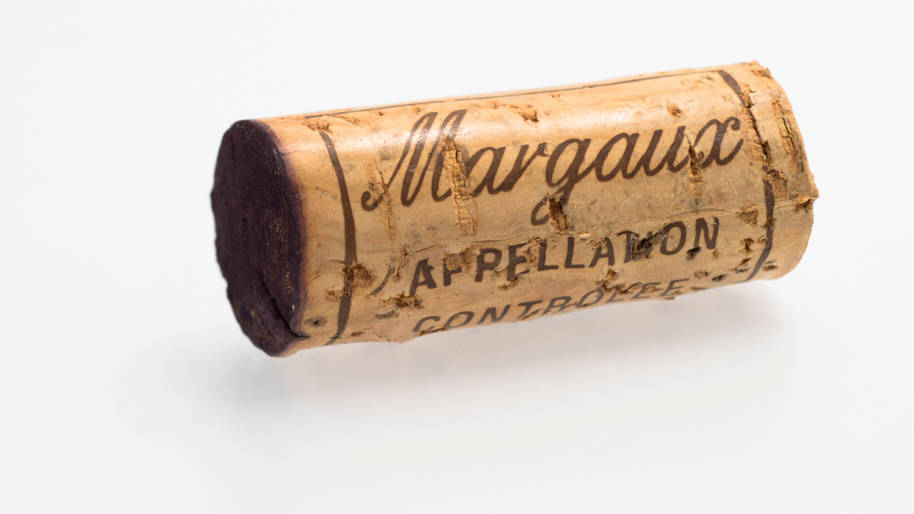 vins de Margaux : bouteille de vin rouge de Margaux avec verre sur table en bois