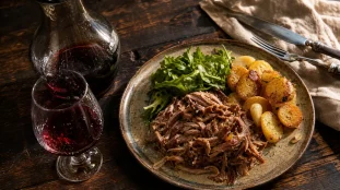 Quel vin avec un confit de canard : confit et vin rouge rubis sur table en bois