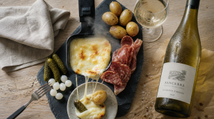 Vin avec la raclette : blanc sec et fromage fondu, table en bois