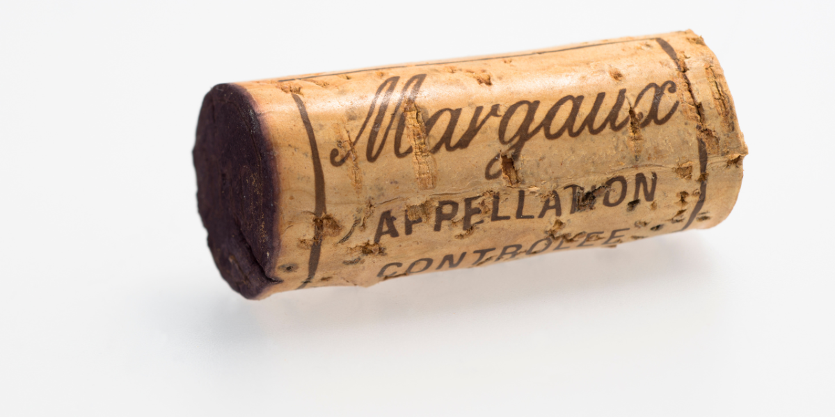 vins de Margaux : bouteille de vin rouge de Margaux avec verre sur table en bois